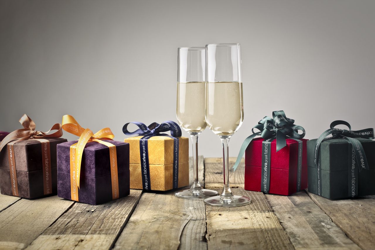 collection-01 Luxurious gifts with ribbons and champagne flutes on a wooden table, perfect for celebrations.